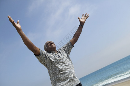 在海滩张开双臂的男人背景图片
