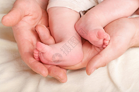 一位父亲抱着他新生儿的脚图片