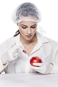 微笑的化学家女人在红苹果里注图片