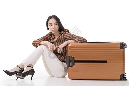 现代亚洲女坐在地上携带行李白色背图片