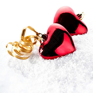 雪地上的两颗红心两颗心在雪地上用金带子心形的圣诞树装饰品情人节2月1图片