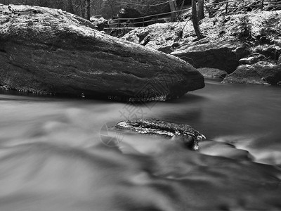 大巨石在溪流清澈的水中冬图片