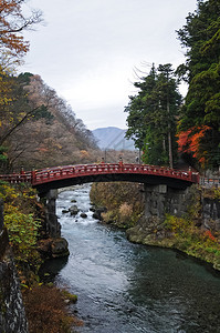 日本古代红弧桥跨越小溪周围环绕着日图片