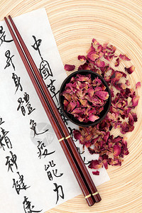 中草药玫瑰花瓣在宣纸上用国语书法文字描述了保持身心健康和平衡身体能图片