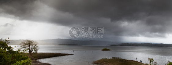 雨中地平线上的山湖全景图片