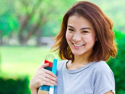 在公园里拿着书的亚洲女人背景图片