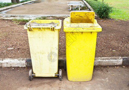 公园里的旧黄色垃圾桶图片