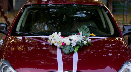 红色婚礼车有白色丝带和花图片