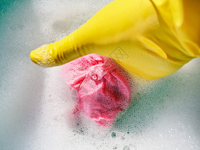 黄橡胶手套用黄色橡胶手套从泡沫图片