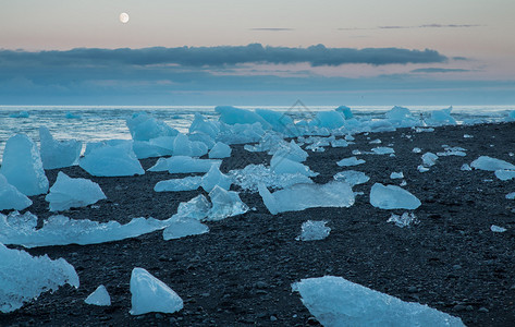 冰岛圆月满日落时在Jokulsarlon冰川环礁湖海滩附近漂图片