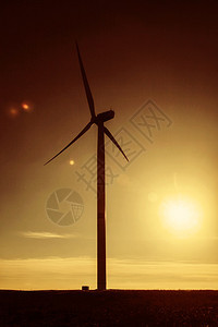 夕阳下的风力发电站涡轮剪影图片