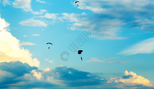 日落时蓝天上不明身份的空中跳伞降图片