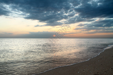 从海边的沙滩上欣赏日落美景图片