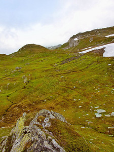 高山的石草甸黑暗的山峰触及厚重的云雾阿尔卑斯山寒冷潮图片