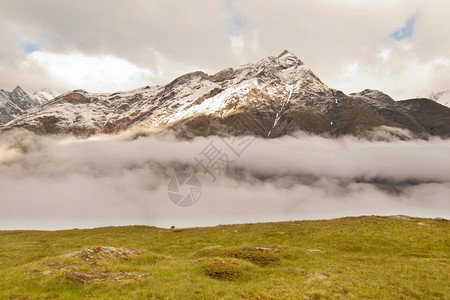 山谷上阿尔卑斯山丘的尖雪图片