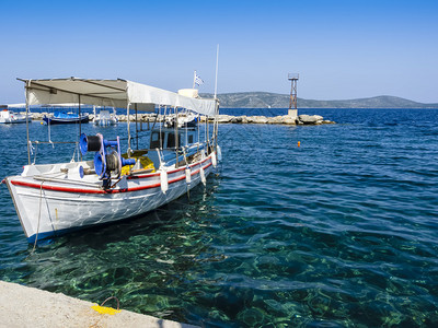 在海面上和面对明蓝天空的木环希腊渔船图片
