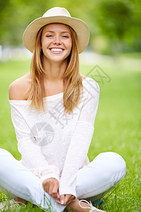 欢乐女孩坐在绿色草地上闲坐着图片