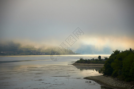 早晨在河的日出反射薄雾图片
