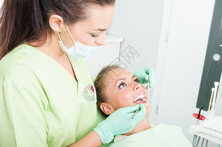 女牙医检查有完美牙齿的女病人图片