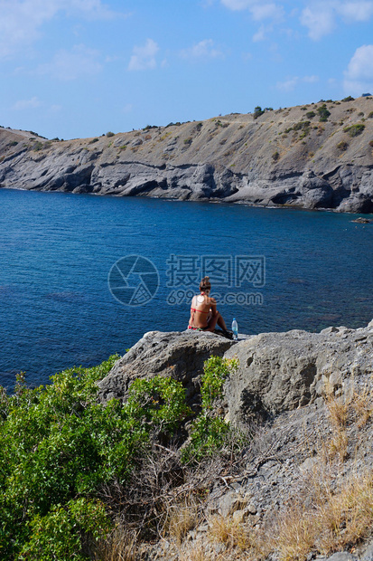 女孩坐在岩石上岩石在海边蓝湾克里米亚图片