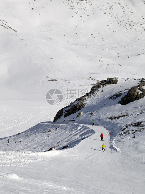 单板滑雪者和滑雪者在阳光日的滑雪坡上图片