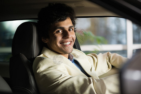 年轻英俊的男人坐在车里的展示厅图片