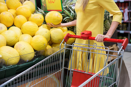 在蔬菜超市购物时选择瓜果的女人图片