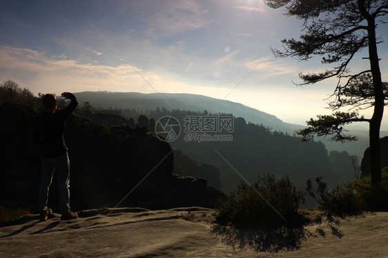 人类坐在岩石帝国公园的山顶上看着秋天的沉雾谷图片