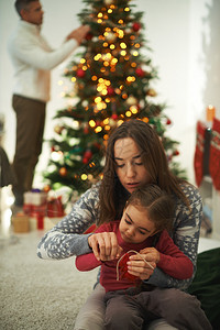 母亲教她女儿如何与在背景上装饰Xma图片