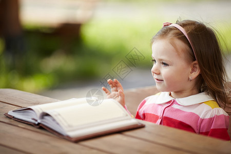 可爱的小女孩在公园看书图片
