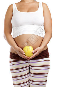 怀孕妇女肚子前拿着苹果图片