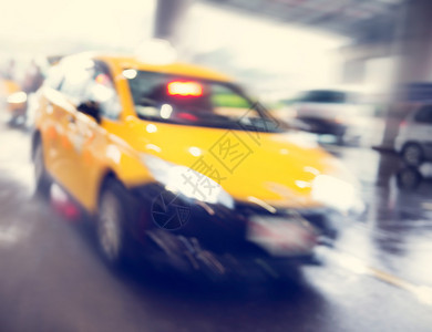 一辆黄色明亮标志出租车超过机场终点楼的灯光入口处图片
