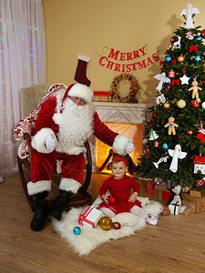 圣诞老人送礼物给家壁炉和圣诞树附近的小可爱女图片