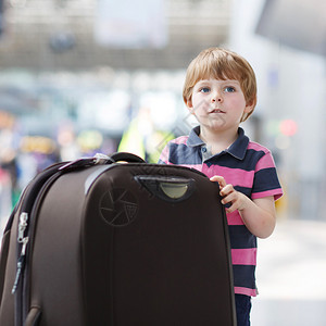 岁的金发男孩带着巨大的手提箱在国际机场图片