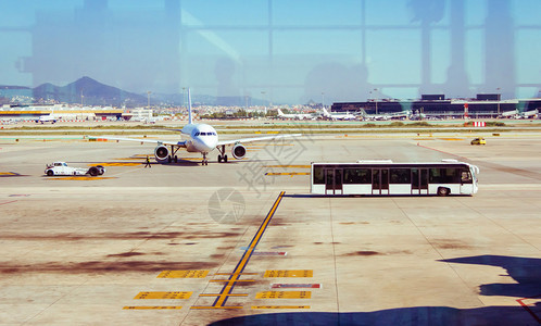 飞机停在简易机场和载客到机场终点站的公共汽车上图片