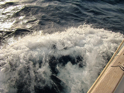快节奏游艇附近的泡沫冲浪背景图片