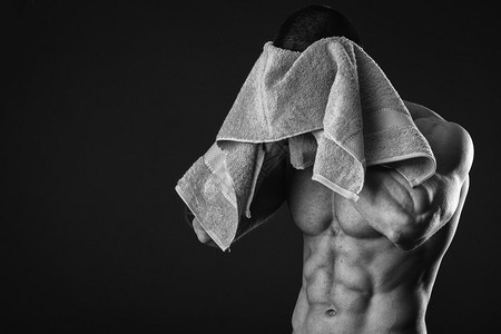 在用黑白毛巾锻炼之后健康的肌肉年轻男子黑图片