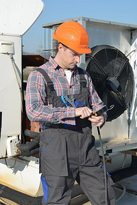 空调修理机修屋顶空调系统的年轻维修员背景图片