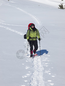 穿着雪鞋和登山杖的人在山上图片