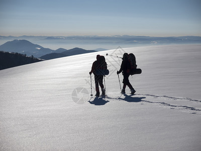 穿着雪鞋和登山杖的人进入山区图片