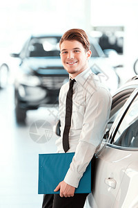 一位英俊的年轻汽车销售员的肖像图片