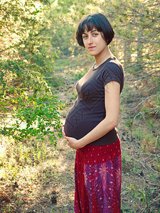 站在夏天森林里的孕妇图片