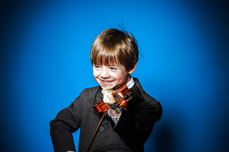 红发学龄前男孩带小提琴孤立蓝图片