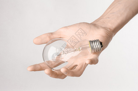 能源消耗和节能专题白底持灯泡的人类手图片