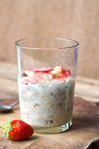 Crunchymusli全谷物燕麦在玻璃碗里配有新鲜草莓和低脂酸奶图片
