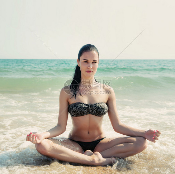 一个美丽的女人在海浪中的海滩上放松图片