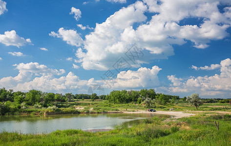 蓝天绿草河流和云彩图片