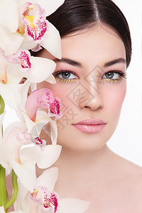 白色兰花与白种背景隔绝的年轻美丽女图片
