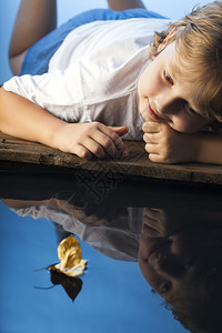男孩在水中玩叶船图片