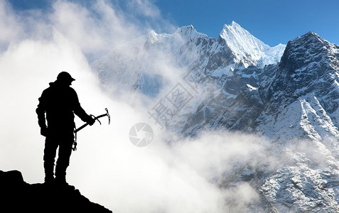 尼泊尔Thamserku山和Kangtega山两座手握有冰斧和山云图片